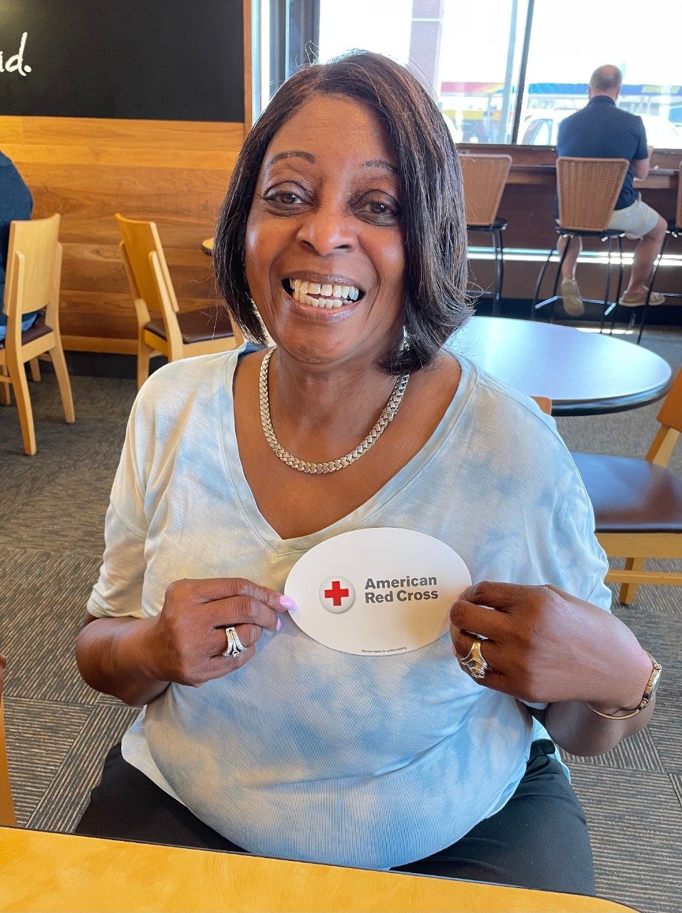 Marilyn Davis, Red Cross volunteer holding red cross sticker