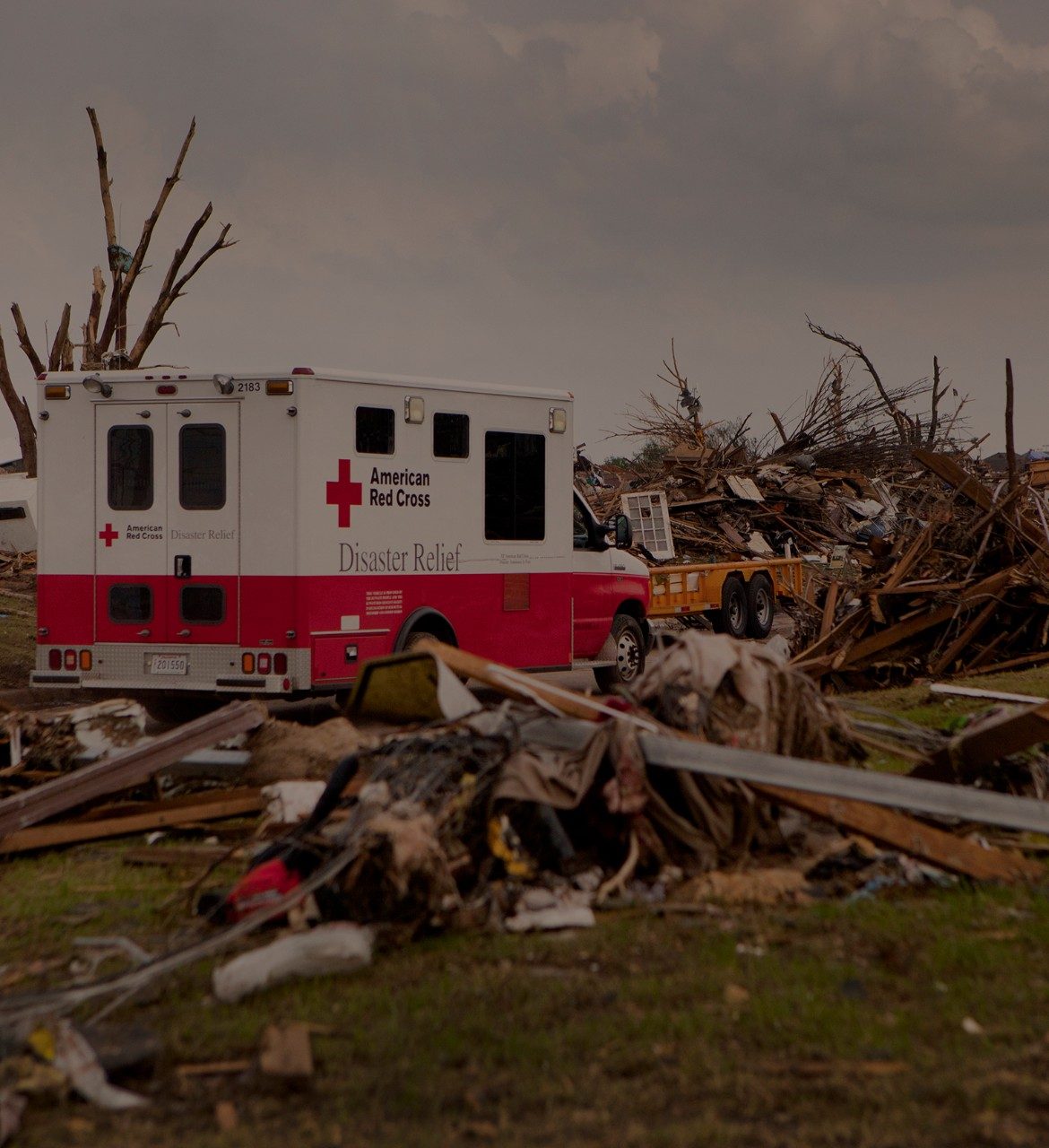 Red Cross emergency response vehicle parked in front of homes destroyed by tornadoes