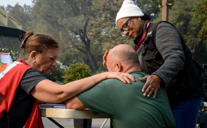 Red Cross volunteers comforting man