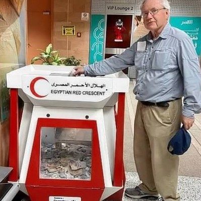 Jim Gallagher standing in front of Egyptian Red Crescent donation box