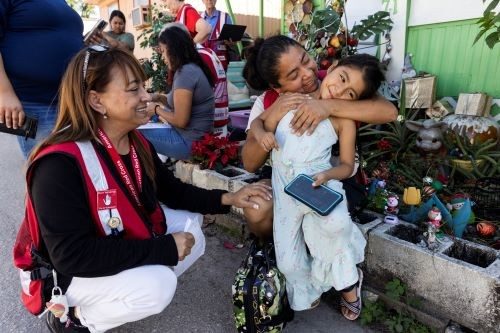 photo of red cross volunteer hugging child