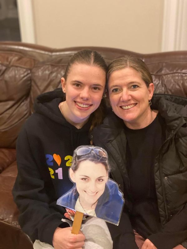 Two females in black sweatshirts holding photo cutout