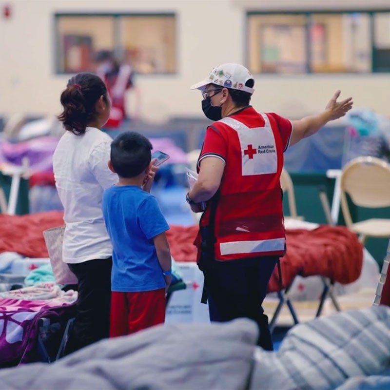 Red Cross volunteers helping mother and son