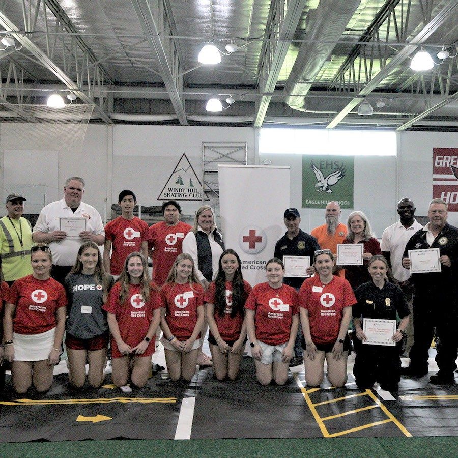 Safety Town participants wearing Red Cross tee-shirts in group photo in high school gym