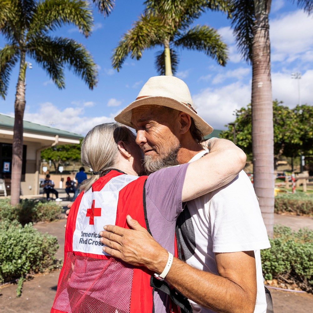 Red Cross volunteer hugging a disaster victim on Maui