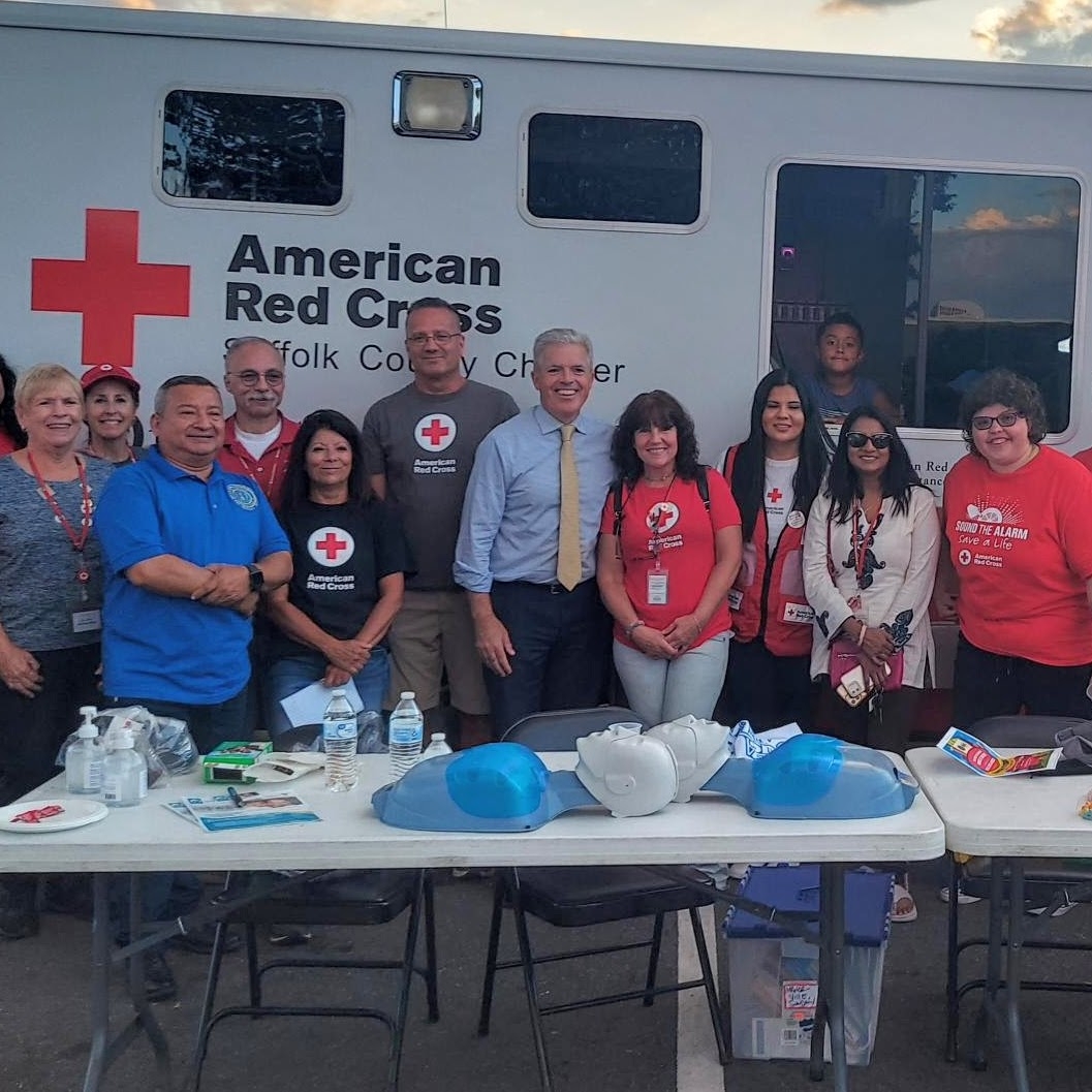 Red Cross team members in front of a table with preparedness information and tools