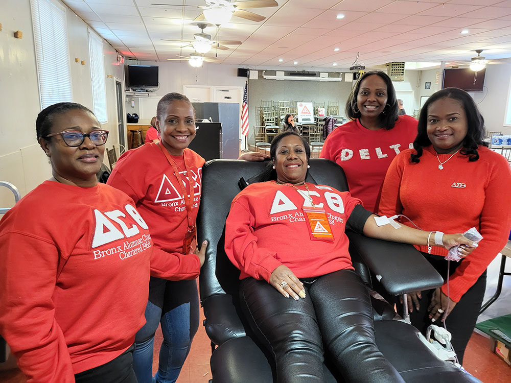 Dr. Angela Green sits on the donation bed while her blood is collected, surrounded by her sisters from the Bronx Alumnae Chapter of Delta Sigma Theta Sorority, Inc.