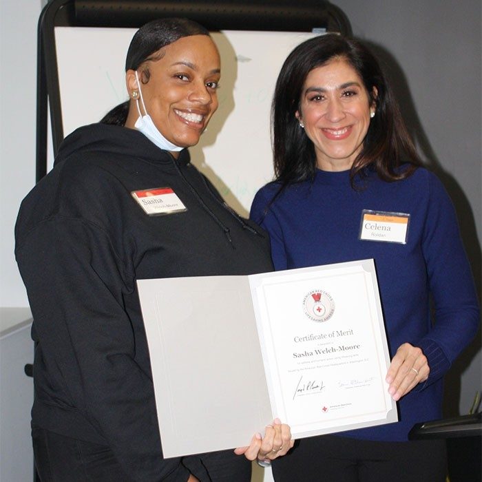 Sasha-Welch Moore and Red Cross employee holding awarded certificate