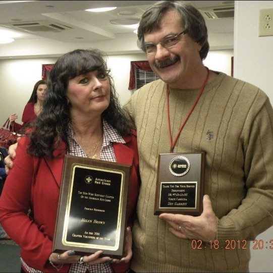 Helen Brown and man pose with awards.