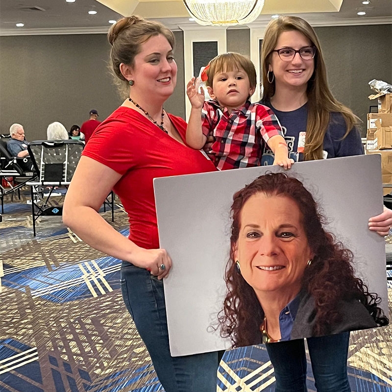 2 ladies holding child and picture of Wendi Winters