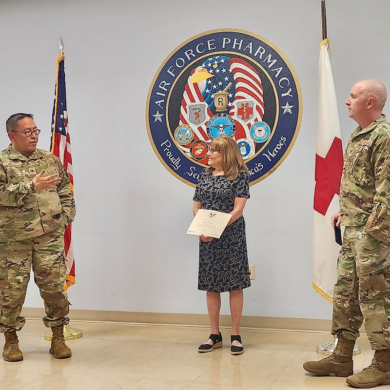 Volunteer presented with award by military personnel