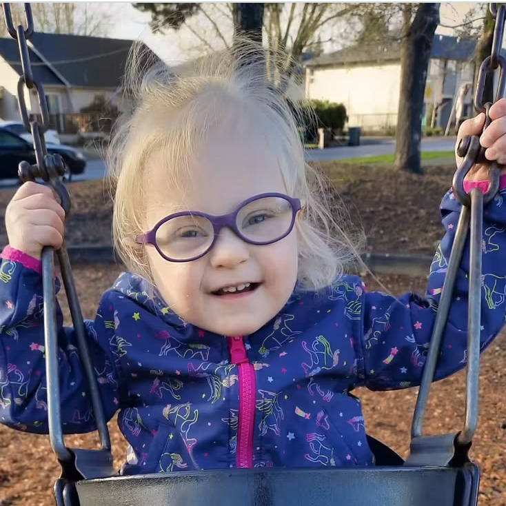 Toddler named Nicole, a blood recipient, sitting on a swing