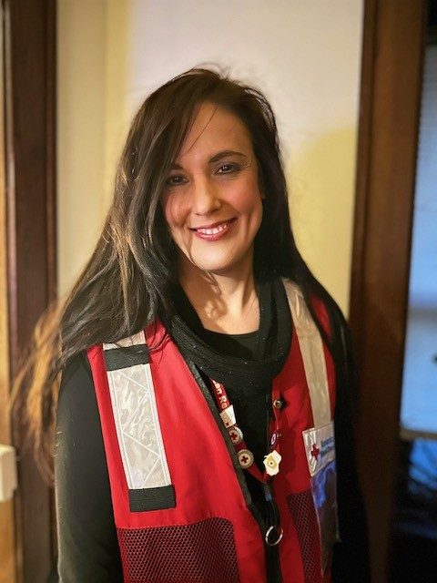 Red cross volunteer Rachael smiling wearing red cross vest