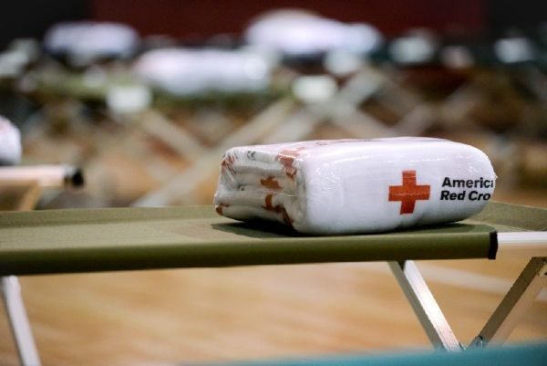 Wrapped up Red Cross blanket on a cot