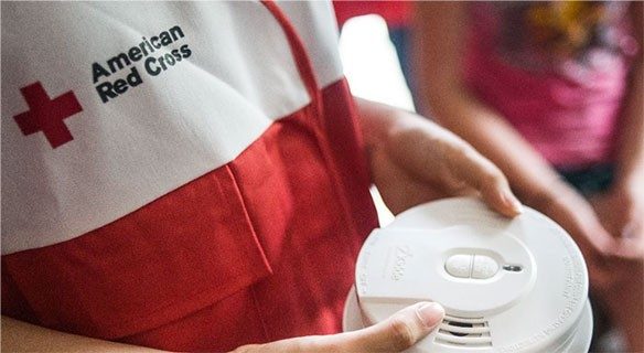 Red Cross volunteer holding a smoke alarm