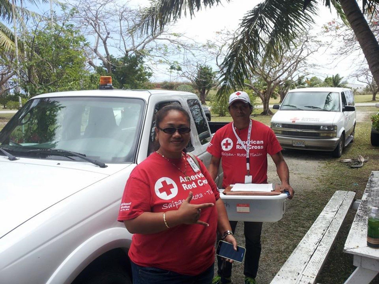 Two Red Cross volunteers next to truck smiling for camera
