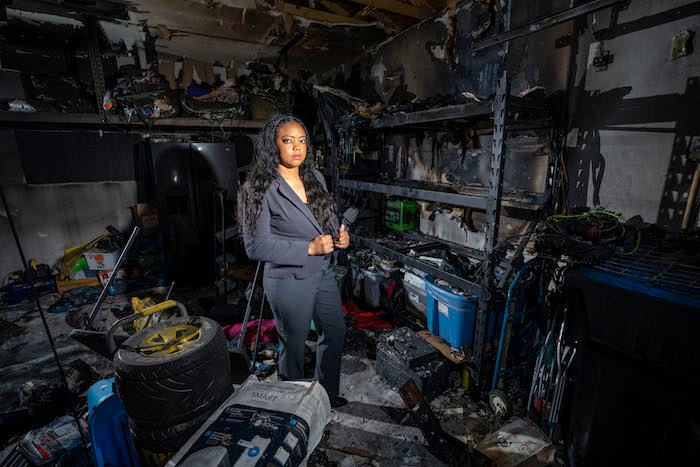Woman standing in storage room damaged by a fire.
