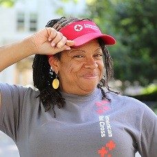Woman wearing Red Cross visor and shirt smiling for camera