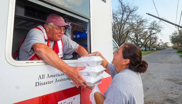 Hurricane survivor Jackie Fiorova receives hot meals for her family from Red Cross volunteer Russ Van Skike in Woodsboro, Texas. Jackie's home and neighborhood suffered sever damage.