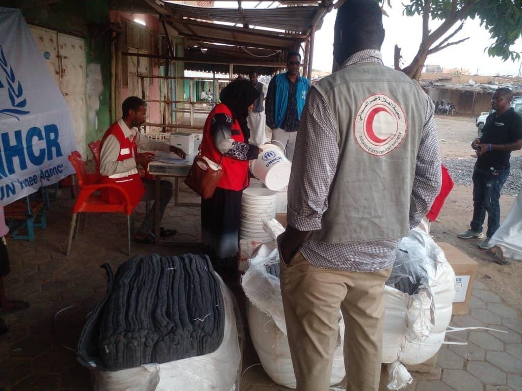 Volunteers of the Sudanese Red Crescent Society distribute non-food items