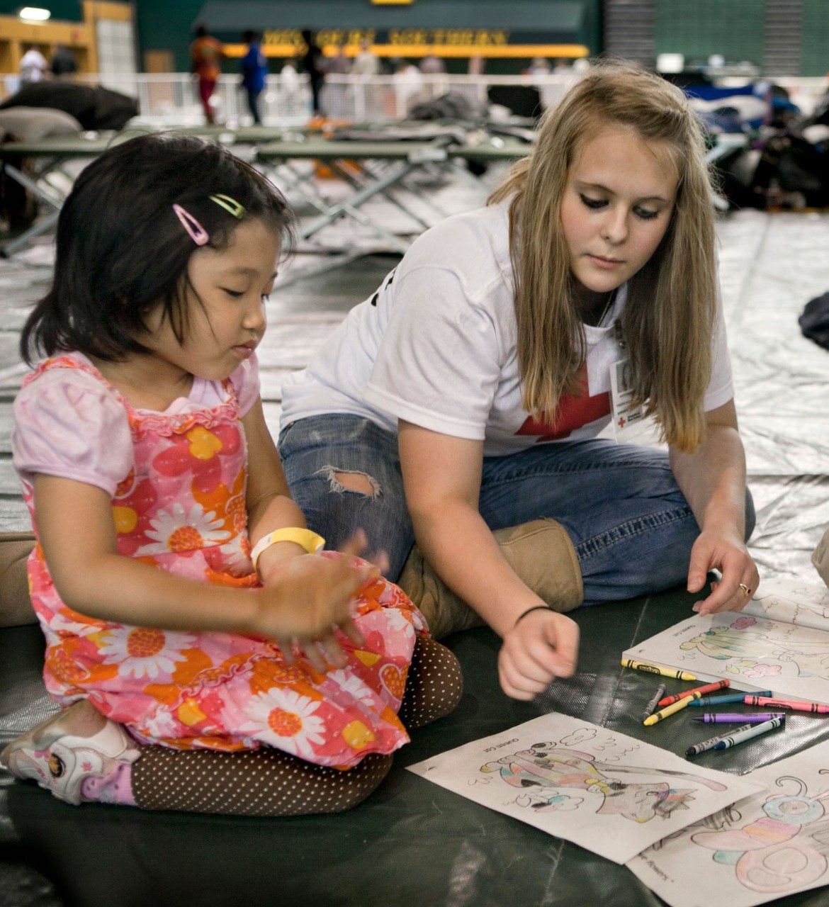Red Cross volunteer coloring with child