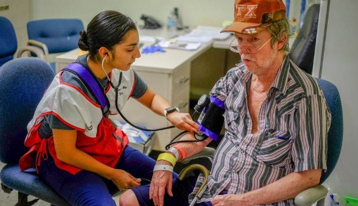 Red Cross Volunteer Nurse Veronica, RN checks the blood pressure of shelter resident Mark