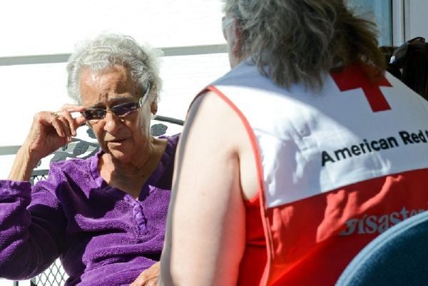 Red Cross volunteer speaking with woman.
