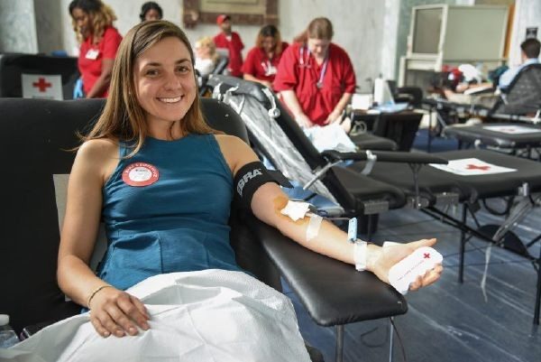Young woman sitting in a chair and giving blood at a blood drive.