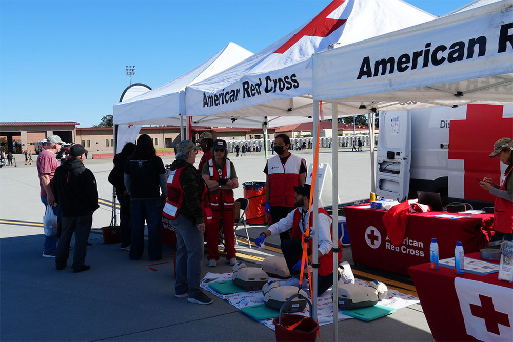 Red Cross volunteers under canopy with CPR manikins