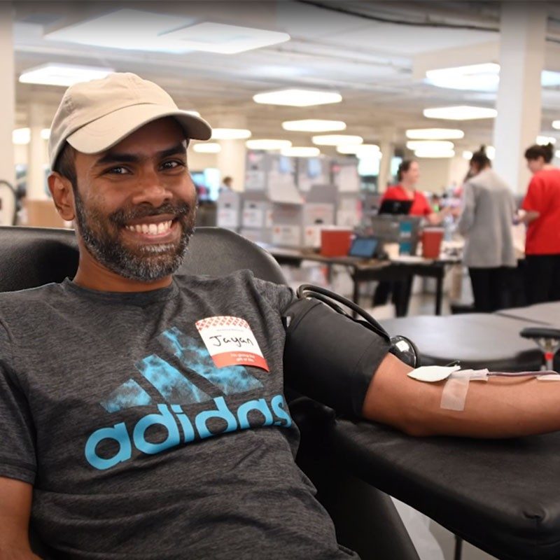 Man donating blood and smiling