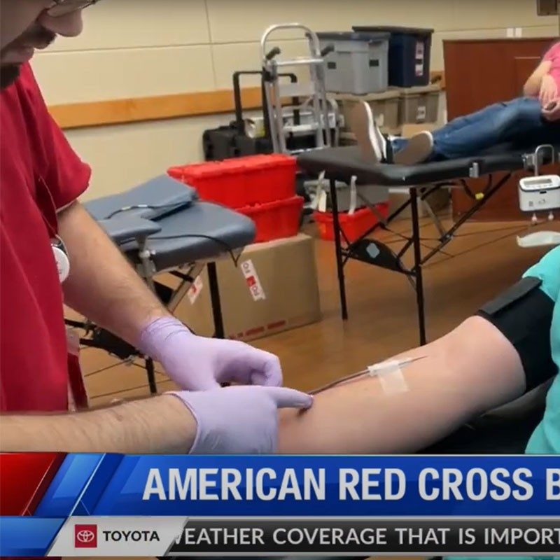 Red Cross nurse taking blood from patient