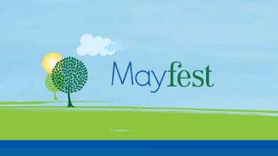 Drawing of trees, sun, cloud, blue sky, green field and water with Mayfest written in sky