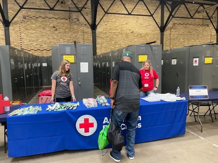 Red Cross representative standing at an information table 