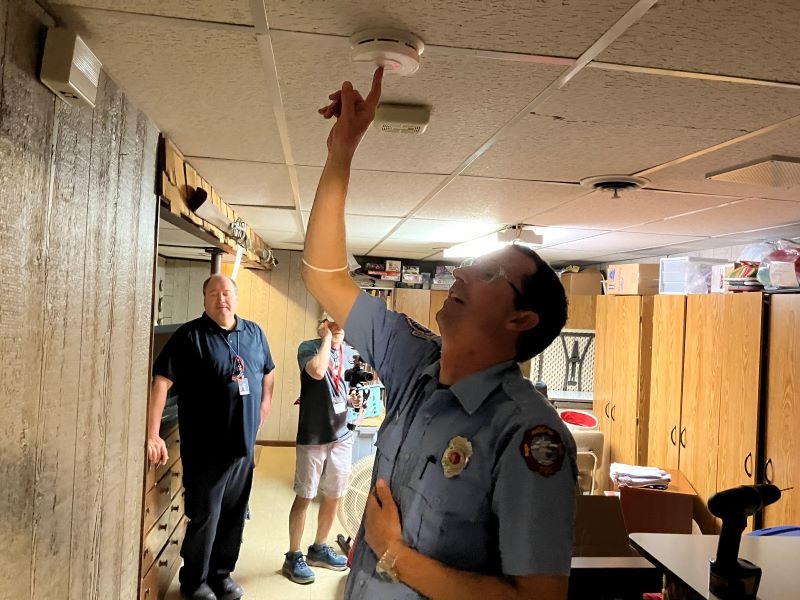 Doug Milks with the Madison Fire Department testing the smoke alarm