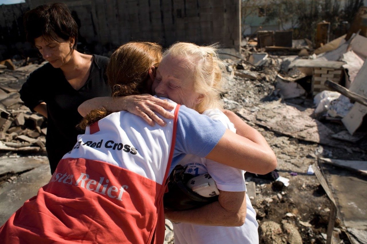 red cross volunteer hugging client