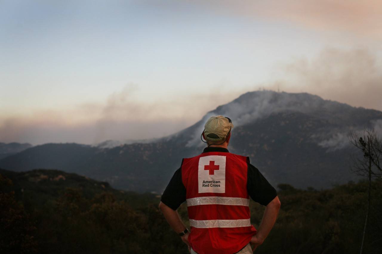 Red Cross worker Ken Krueger watches the Harris Fire burning in the southeastern section of San Diego County.
