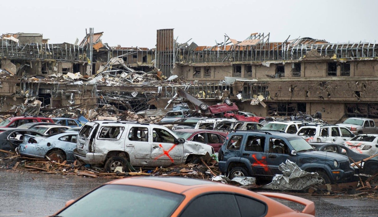 A building and cars damaged by a tornado.