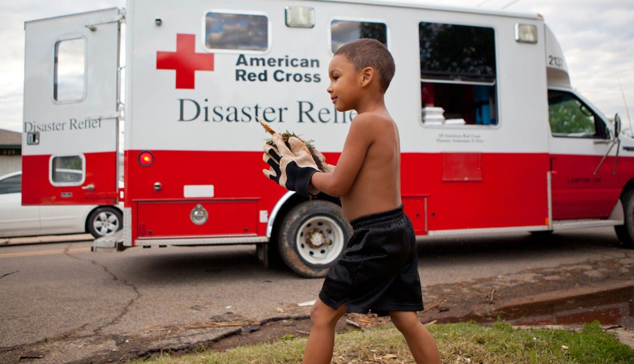 A young boy clearing debris from a front yard