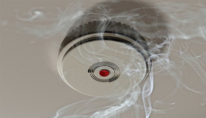 Smoke alarm with wisps of smoke around it