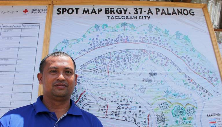 Artemio Insigne stands in front of a community map