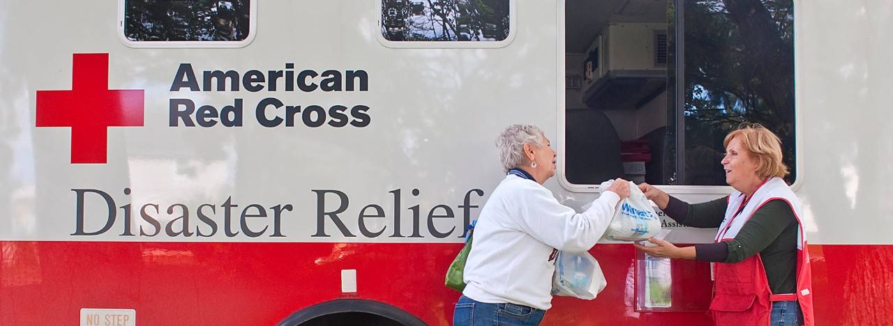 September 16, 2011. Vestal, New York.  Barbara Butz of Vestal get hot meals from an American Red Cross volunteer April Reppetto of Nevada as cleanup from the floods continues. Photo by Chuck Haupt /American Red Cross
