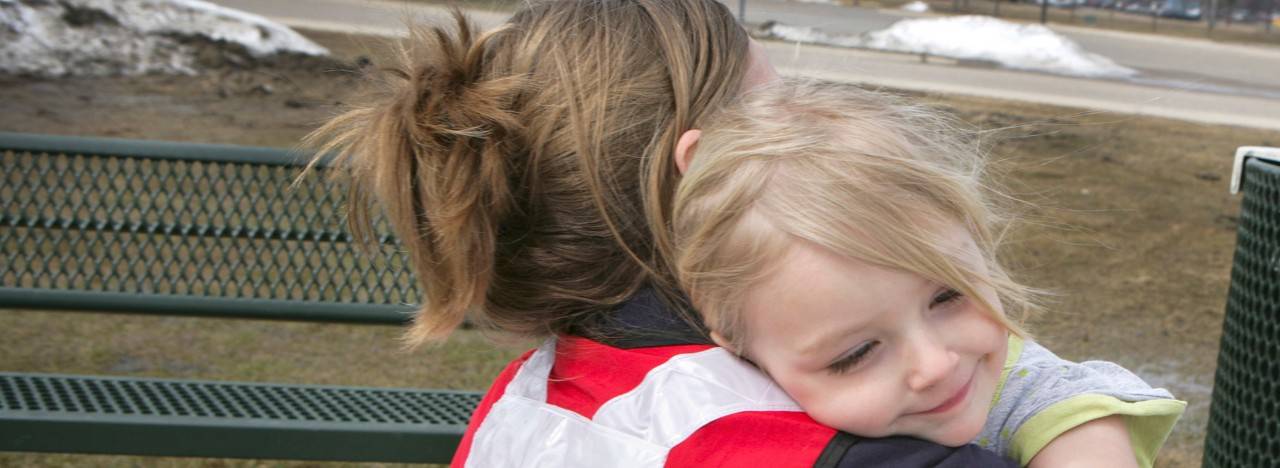 April 9, 2011. Fargo, North Dakota. While in Fargo, North Dakota, Red Cross volunteer Lynette Nyman shares a hug with Ava on a playground. Photo by Talia Frenkel/American Red Cross