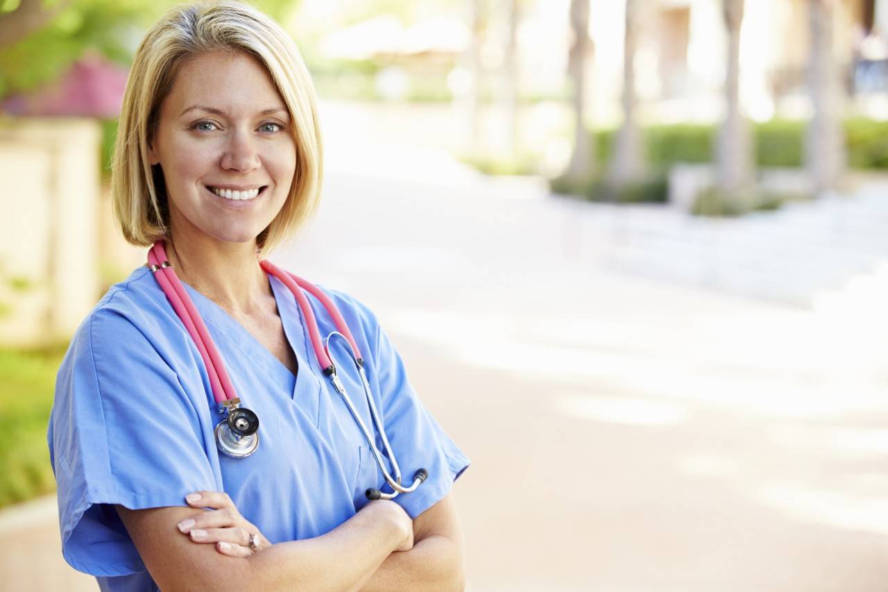 Outdoor Portrait Female Nurse, Female nurse looking into camera with background
