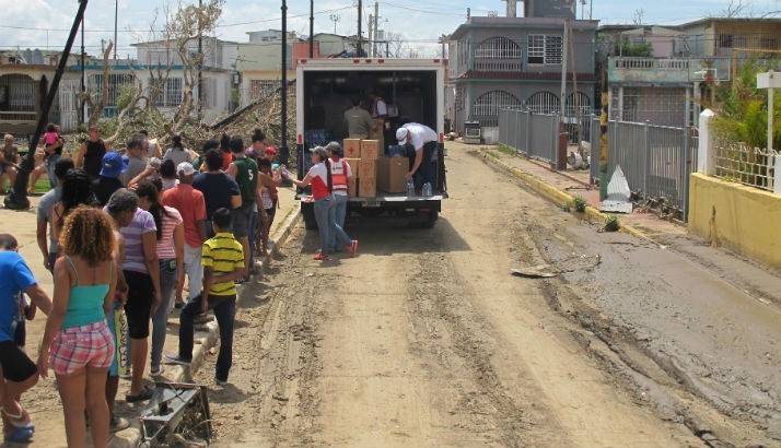 Red Cross volunteers distribute water, food and other basic necessities to families affected by Hurricane Maria.