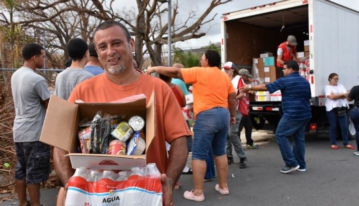 A man accesses drinking water and other supplies after Hurricane Maria