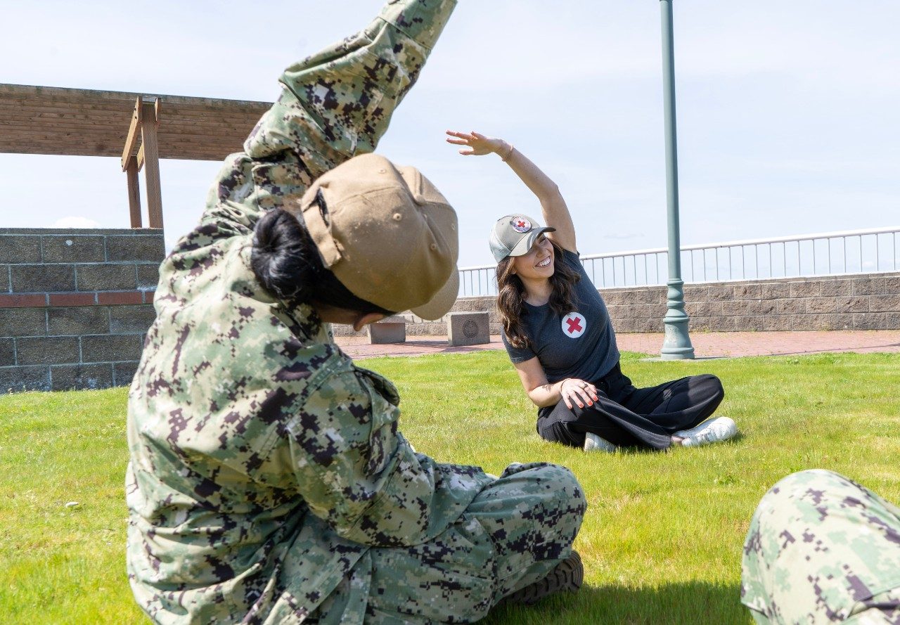 volunteers and US service member assisting woman in wheelchair