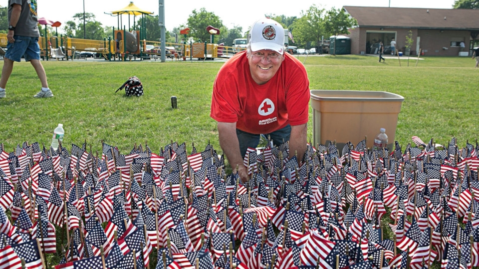 Red Cross Volunteer Plants Flags