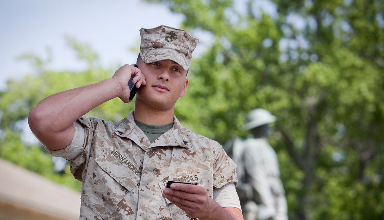 Young man in military uniform talking on phone