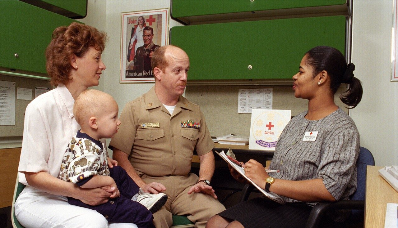 Red Cross volunteer speaking with military family
