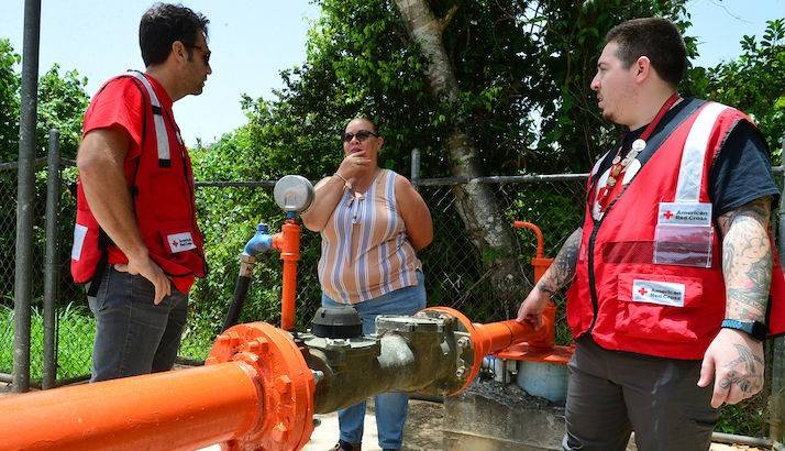 Community leader Maribel Torres speaks with Red Cross volunteers about her community well.